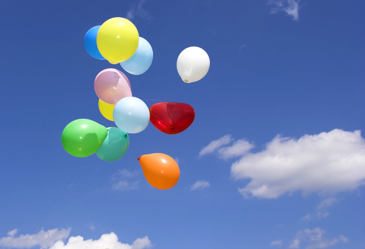 Colorful Balloons Floating in Clear Blue Sky