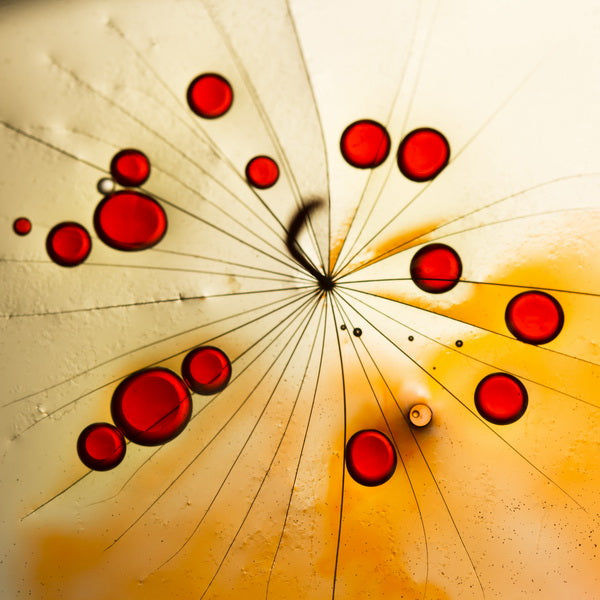 Radiant Red Droplets on Amber Abstract Surface
