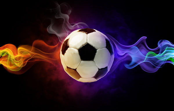 Energetic Kickoff: A Soccer Ball Surrounded by Vibrant Smoke Trails