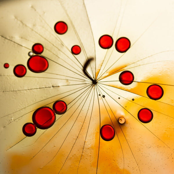 Radiant Red Droplets on Amber Abstract Surface